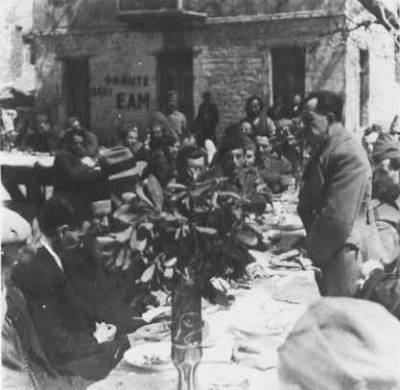 Μάιος 1944, Εδρα ΠΕΕΑ, Κεράσοβο Ευρυτανίας: Υπαίθριο τραπέζι, πιθανόν εορτασμός Πάσχα. Ο Στέφανος Σαράφης όρθιος ομιλητής και σύνθημα 'Ψηφίστε όλοι ΕΑΜ'
