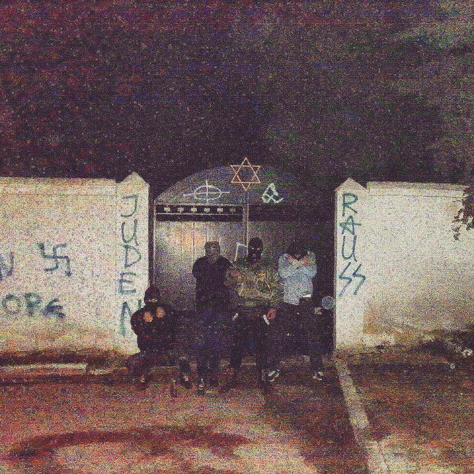 'Ανένταχτοι Μαιάνδριοι Εθνικιστές Larissa Skins', Εξω από τη βεβηλωμένη με ναζιστικά συνθήματα και σύμβολα είσοδο του Εβραϊκού Νεκροταφείου της Λάρισας.