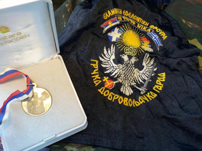 Αριστερά το Μετάλλιο του Λευκού Αγγέλου, ανώτατη διάκριση από τη Σερβοβοσνιακή Δημοκρατία προς τους Ελληνες εθελοντές της ΕΕΦ και δεξιά το φορετό σήμα της ΕΕΦ, με τον αποτυχημένο ήλιο της Βεργίνας