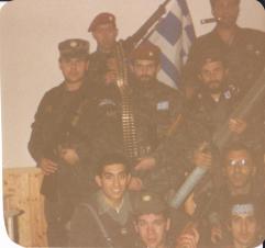 Βλασένιτσα Βοσνίας, Φεβρουάριος 1995, προφανώς στη βάση του στρατοπέδου της ΕΕΦ ή ίσως σε κάποιο από τα κατασχεμένα μουσουλμανικά οικήματα που είχαν παραχωρηθεί στους Ελληνες, κατόπιν διαταγής του Μλάντιτς. Διακρίνονται οι Μήτκος Αντώνιος (διοικητής της ΕΕΦ), Βασιλειάδης Τρύφων (υποδιοικητής της ΕΕΦ), Μουρατίδης Γιώργος, Καθάριος Κυριάκος, Κώστας (αγνώστων λοιπόν στοιχείων, ίσως να πρόκειται για τον καταγεγραμμένο εθελοντή Κώστα Λαμπρόπουλο), Λάτσιος Αγγελος του 10ου Αποσπάσματος Σαμποτάζ, Νικολαΐδης Νίκος και το μέλος της Χρυσής Αυγής ΜΜ. Επιδεικνύουν -υποθέτουμε- τον βαρύ οπλισμό τους.
