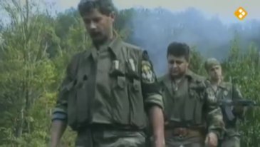 Ημέρες των θηριωδιών, 13 Ιουλίου 1995, Σρεμπρένιτσα, Βοσνία. Σε πρώτο πλάνο, ο Ελληνορουμάνος Φλορίν Αννα κά. Με τα όπλα γεμάτα και το δάχτυλο στην σκανδάλη, ξεκινάνε μαζί με Σέρβους ένοπλους παραστρατιωτικούς για κυνήγι Μουσουλμάνων, πιθανώς με την μέθοδο της ενέδρας.