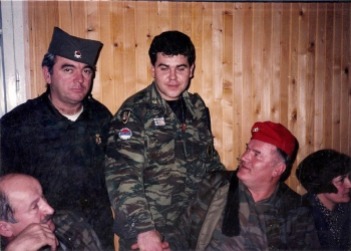 Πρωτοχρονιά 1996. Στο αρχηγείο του σερβοβοσνιακού στρατού του Μλάντιτς, στο Han Pijesak, μια όμορφη γιορτή με τον Μλάντιτς στο τσακίρ-κέφι, φορώντας ελληνικό τσολιαδίστικο φέσι και τον Αντώνη Μήτκο να διασκεδάζουν και να χορεύουν. Το φέσι του τσολιά συναντάει την Sajkaca και τα 4 κυριλλικά 'C' του σερβικού σταυρού («Samo sloga Srbina spasava», «μόνο η ενότητα θα σώσει τους Σέρβους»).