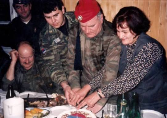 Πρωτοχρονιά 1996. Στο αρχηγείο του σερβοβοσνιακού στρατού του Μλάντιτς, στο Han Pijesak, μια όμορφη γιορτή με τον Μλάντιτς στο τσακίρ-κέφι, φορώντας ελληνικό τσολιαδίστικο φέσι και τον Αντώνη Μήτκο να διασκεδάζουν και να χορεύουν. Το φέσι του τσολιά συναντάει την Sajkaca και τα 4 κυριλλικά 'C' του σερβικού σταυρού («Samo sloga Srbina spasava», «μόνο η ενότητα θα σώσει τους Σέρβους»).