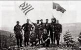 Βλασένιτσα, Βοσνία, 1995. Διακρίνονται με μια ελληνική και μια σερβική σημαία τα μέλη της Χρυσής Αυγής Μπέλμπας Απόστολος και Κουσουμβρής Σωκράτης με τις πατερίτσες και οι Κώστας, Βασιλειάδης Τρύφων, Δημητρίου Χρήστος, Φλορίν Αννα και άλλοι.