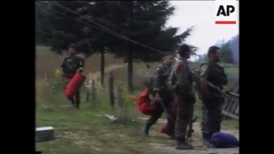 Σρεμπρένιτσα, Βοσνία, 11 Ιουλίου 1995. Τα μέλη της ΕΕΦ Τζανόπουλος, Σχιζάς, Ζαβιτσάνος κά. στο στρατόπεδο, μαζί με τους 'Λύκους τους Δρίνου'. Στην επιχείρηση κατάληψης της Σρεμπρένιτσα, φτιάχτηκαν ειδικά και έκτακτα σώματα, αποκλειστικά για τις συγκεκριμένες επιχειρήσεις. Λ.χ. ο αντισυνταγματάρχης Παντούρεβιτς της Zvornik Brigade έφτιαξε ένα επίλεκτο σχηματισμό με το όνομα TG-1 (Tactical Group 1) και υπέδειξε για διοικητή τον λοχαγό Milan Jolovic (με το ψευδώνυμο Legenda), τον διοικητή των 'Λύκων του Δρίνου'. Διακρίνονται τα μέλη της ΕΕΦ να μεταφέρουν εξοπλισμό.