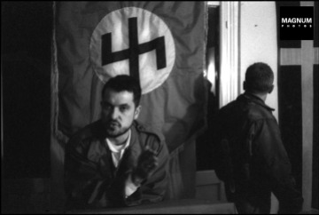 Στα γραφεία της Χρυσής Αυγής, Μιχαλολιάκος, Παππάς, Περίανδρος και άλλοι, κάτω από τη σημαία με τον ρούνο Wolfsangel, το έμβλημα της 4ης Polizei Division των SS, που ήταν υπεύθυνη για τις σφαγές αμάχων σε Δίστομο και Κλεισούρα, Φωτογραφίες Nicos Economopoulos, Magnum Photos http://www.magnumphotos.com/Asset/-2TYRYDIX2BQU.html