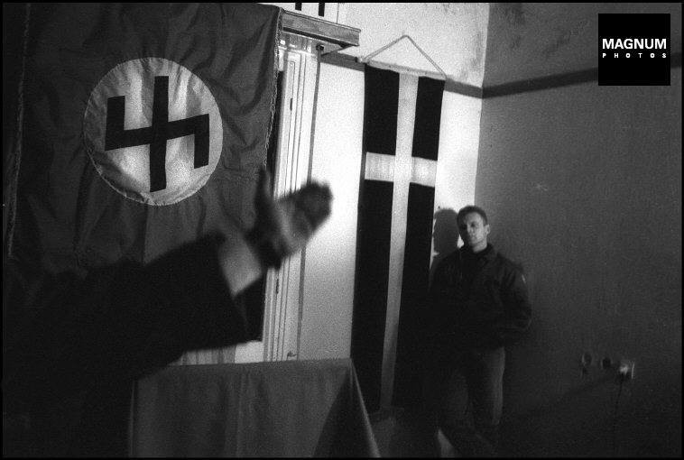 Στα γραφεία της Χρυσής Αυγής, Μιχαλολιάκος, Παππάς, Περίανδρος και άλλοι, κάτω από τη σημαία με τον ρούνο Wolfsangel, το έμβλημα της 4ης Polizei Division των SS, που ήταν υπεύθυνη για τις σφαγές αμάχων σε Δίστομο και Κλεισούρα, Φωτογραφίες Nicos Economopoulos, Magnum Photos http://www.magnumphotos.com/Asset/-2TYRYDIX2NG1.html
